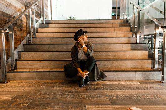 A woman sitting in front of a staircase