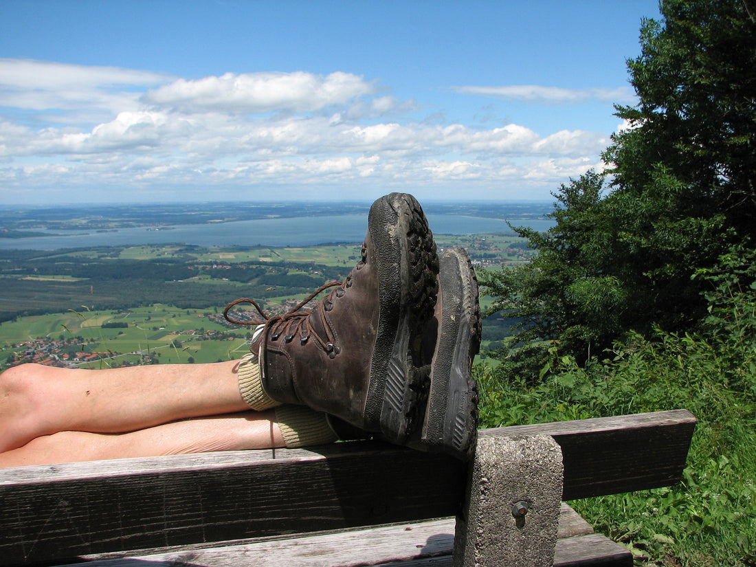 A man relaxing on a bench wearing summer hiking shoes