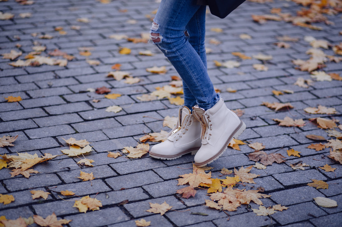 A person wearing neutral-colored-shoes with blue jeans
