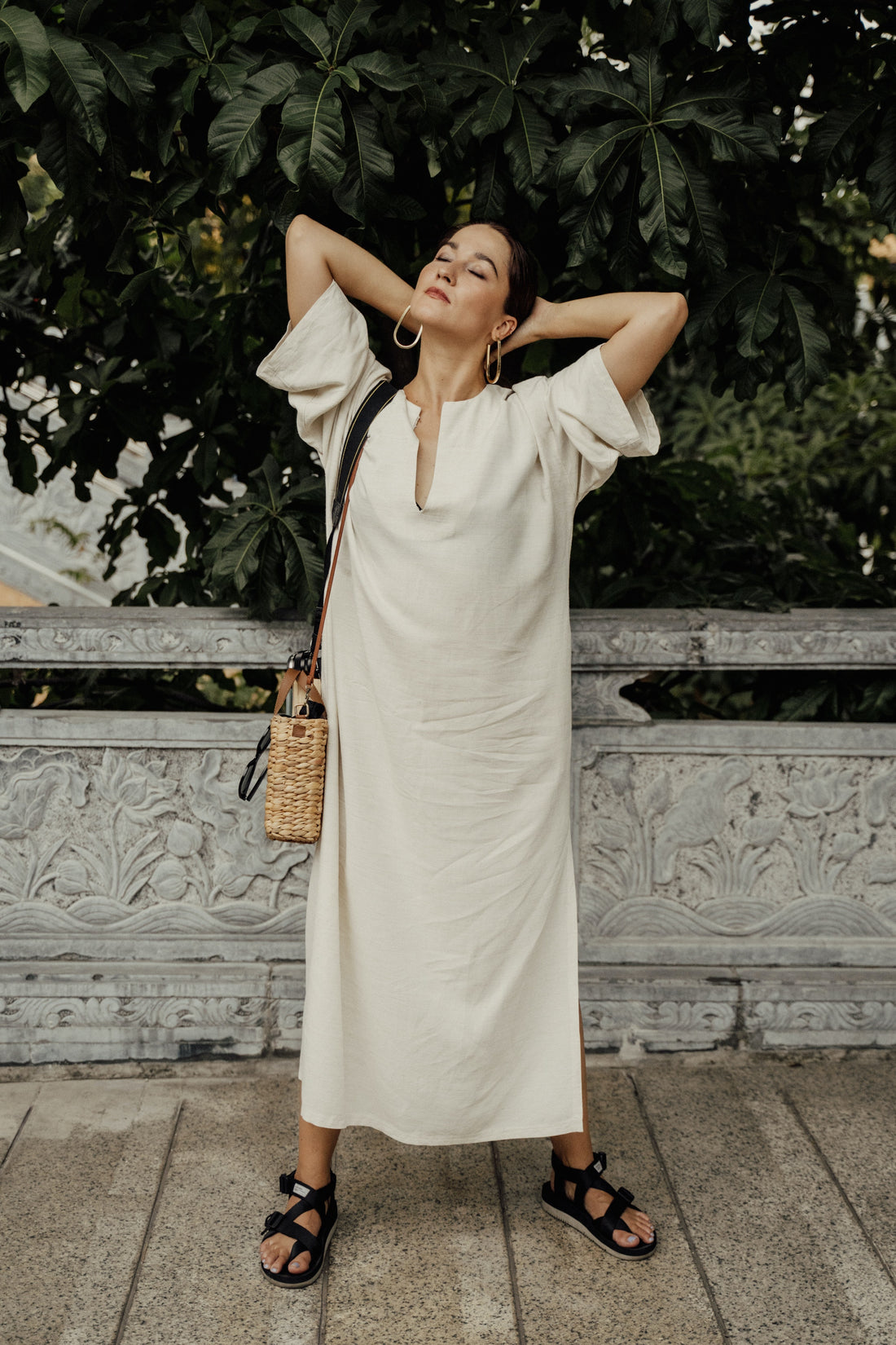 A woman wearing a dress and summer orthopedic sandals with supportive straps.